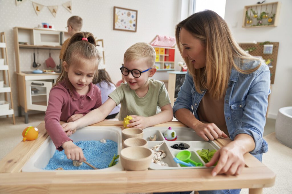 Physiotherapist guiding two children through a sensory learning activity in a dyslexia-friendly classroom.